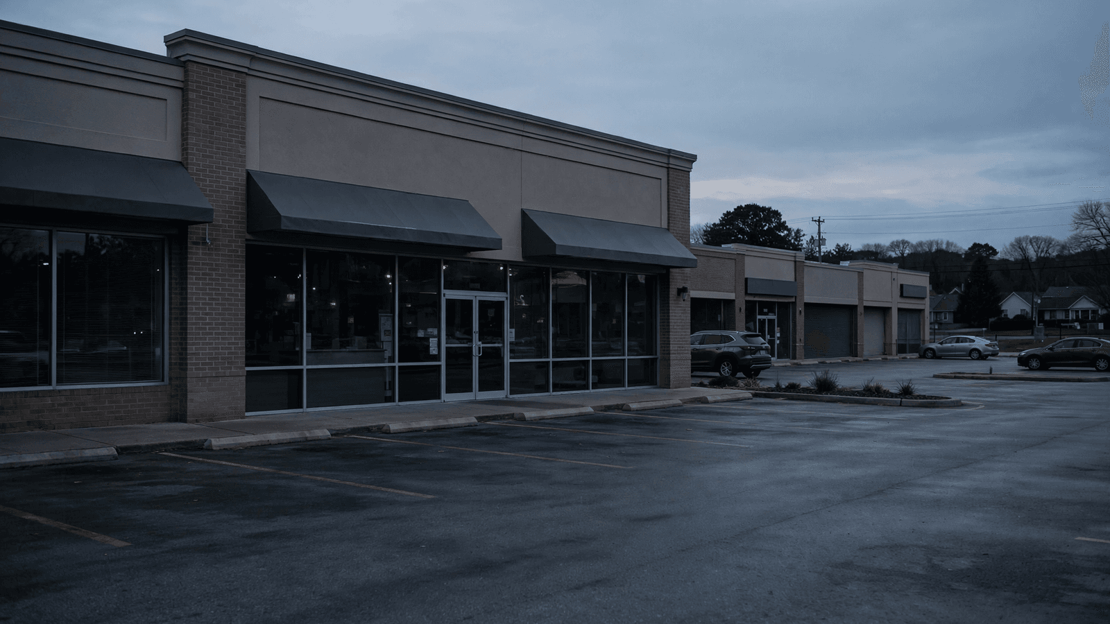 Walgreens pharmacy storefront closing — empty lot at dusk